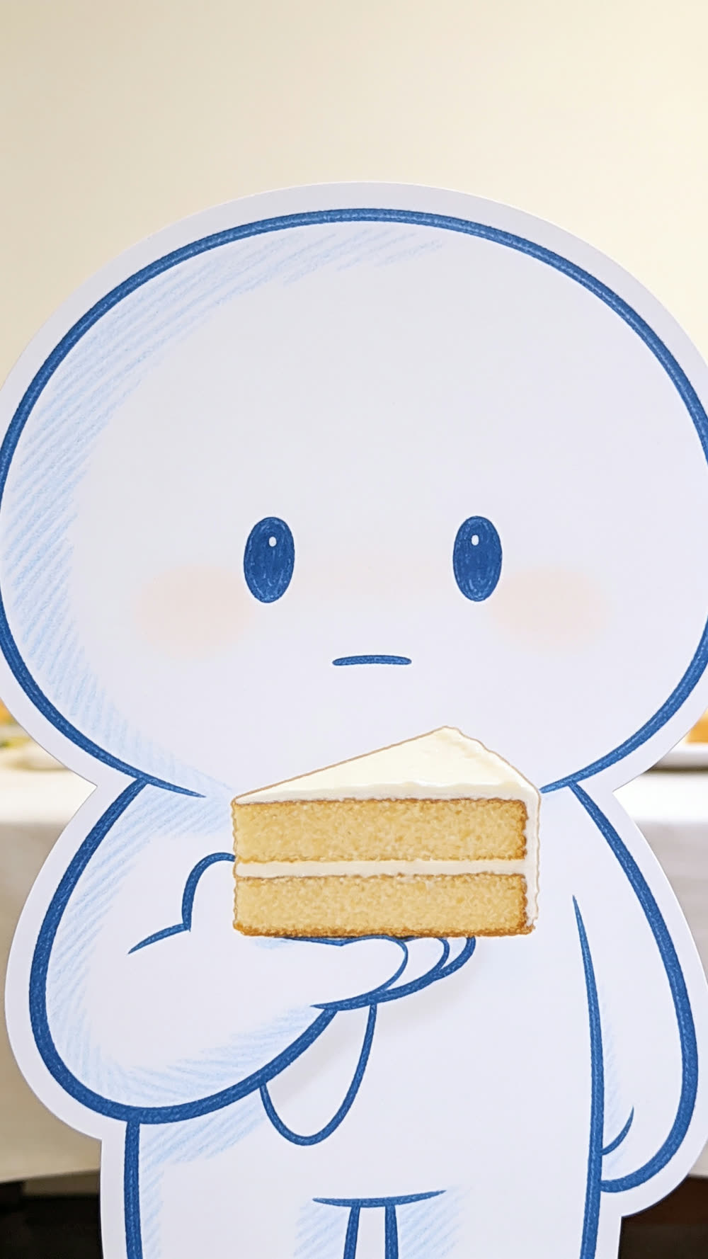 Close up of the mascot's deadpan face, holding the large cut piece of cake just below its chin, perfectly still, no expression at all.